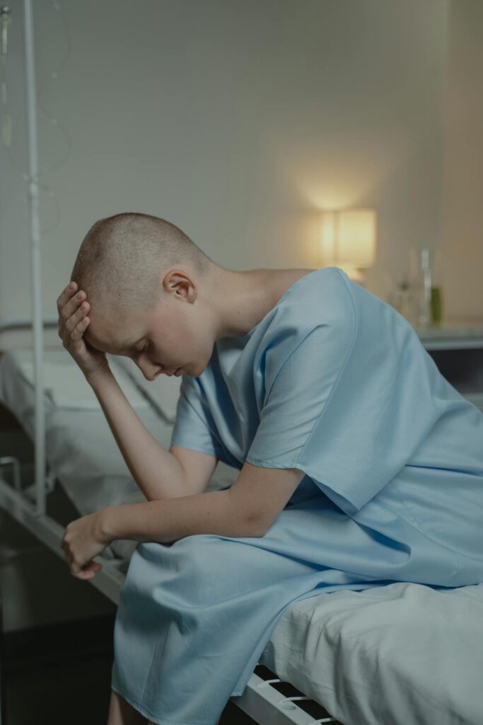 A Sick Woman Sitting on the Hospital Bed