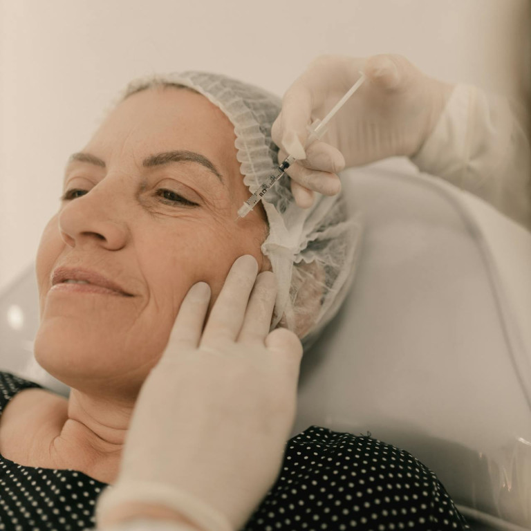 Middle-aged woman receiving cosmetic facial injection